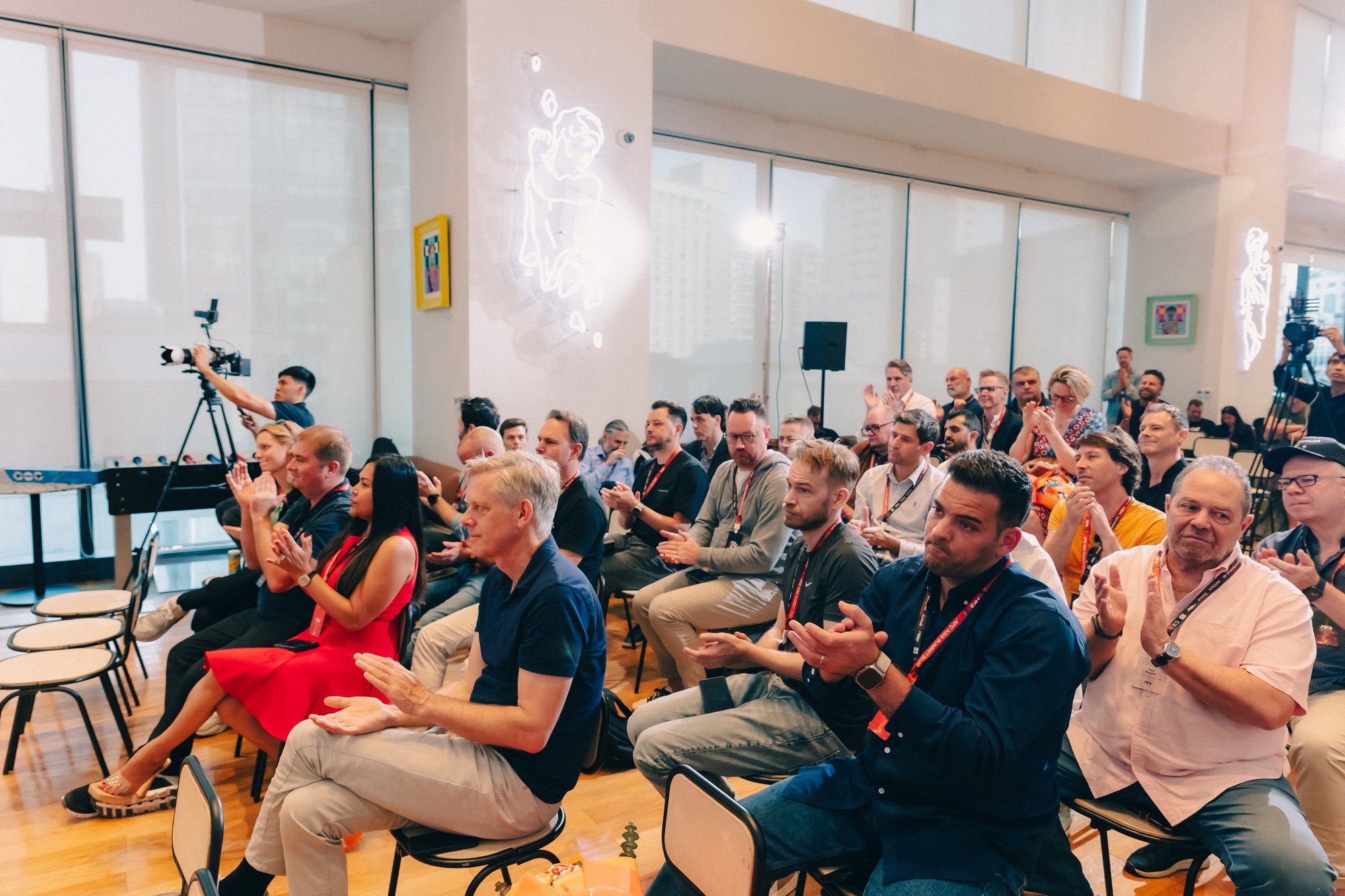 Event Participants applauding in a bright conference room.